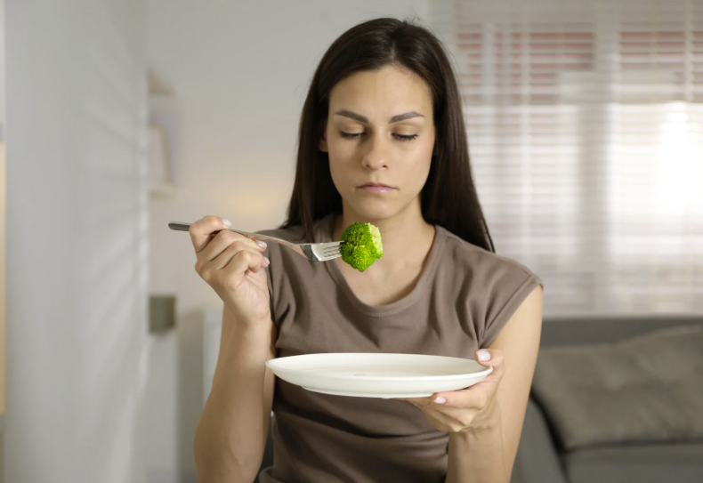 The silver nutritionist body image page depicting a young woman attempting to eating a small portion of
food