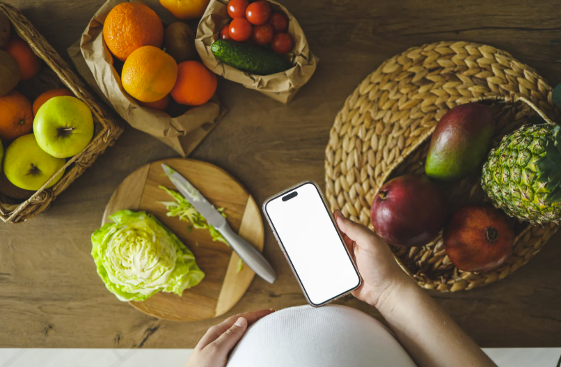 pregnancy (4) the silver nutritionist image depicting Customised nutrition plans tailored to preconception, pregnancy, and postpartum needs with a pregnant woman noting surrounding fresh produce
