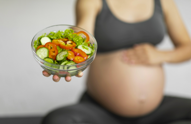 the silver nutritionist image depicting Comprehensive Nutrition Guidance for Every Stage of Parenthood represented by a food bowl and a pregnant mother blurred in the background